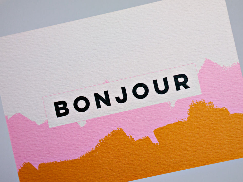 The completist pink mustard bonjour brushstroke postcard